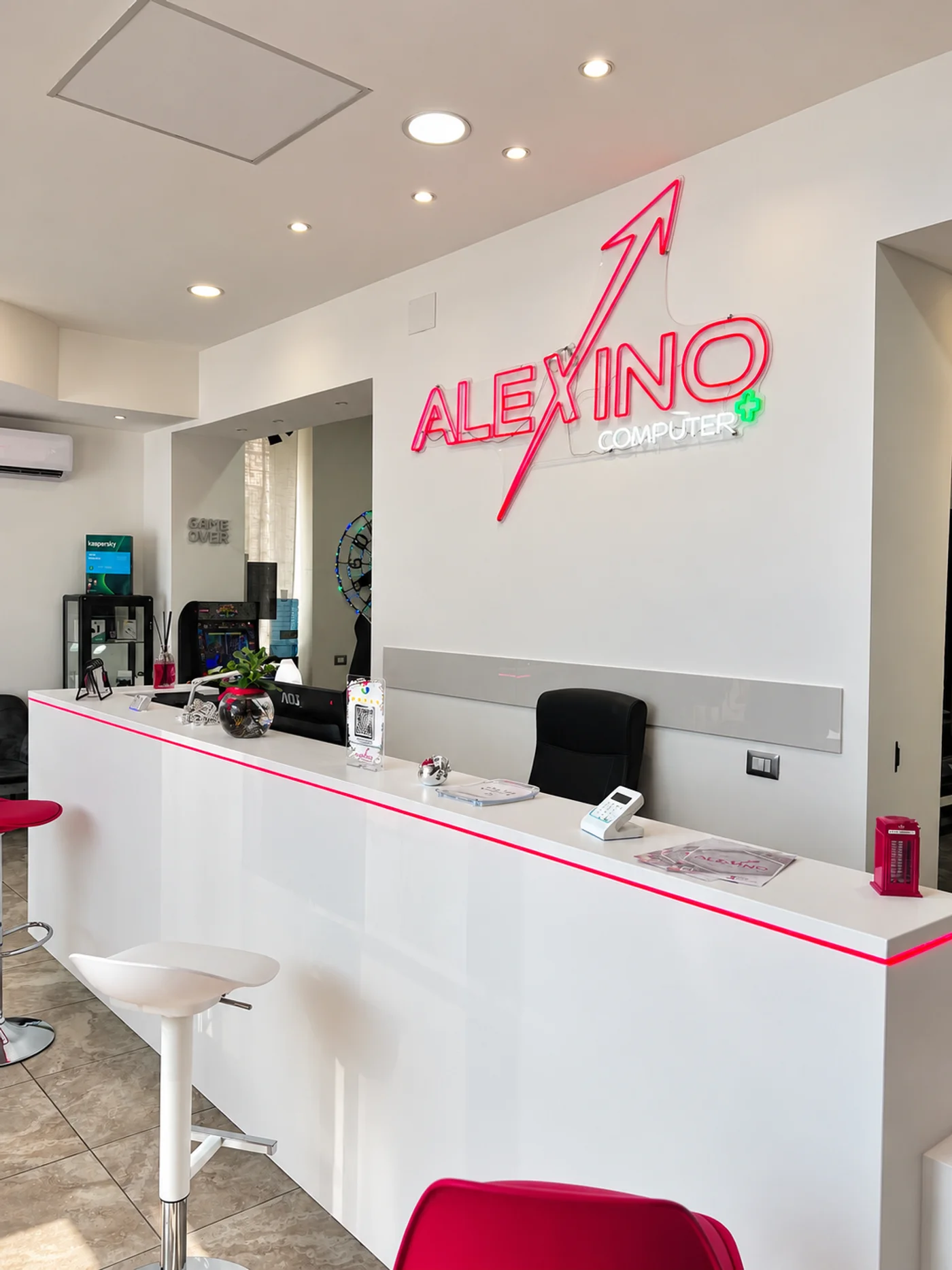 Banco di accoglienza e insegna luminosa del negozio Alexino a Ciampino